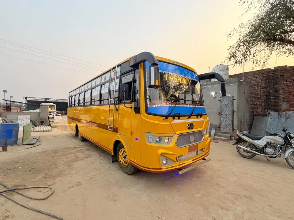 School bus, yellow with blue front, front three-quarter view — built by Guru Kirpa Bus Body Builders, Barnala